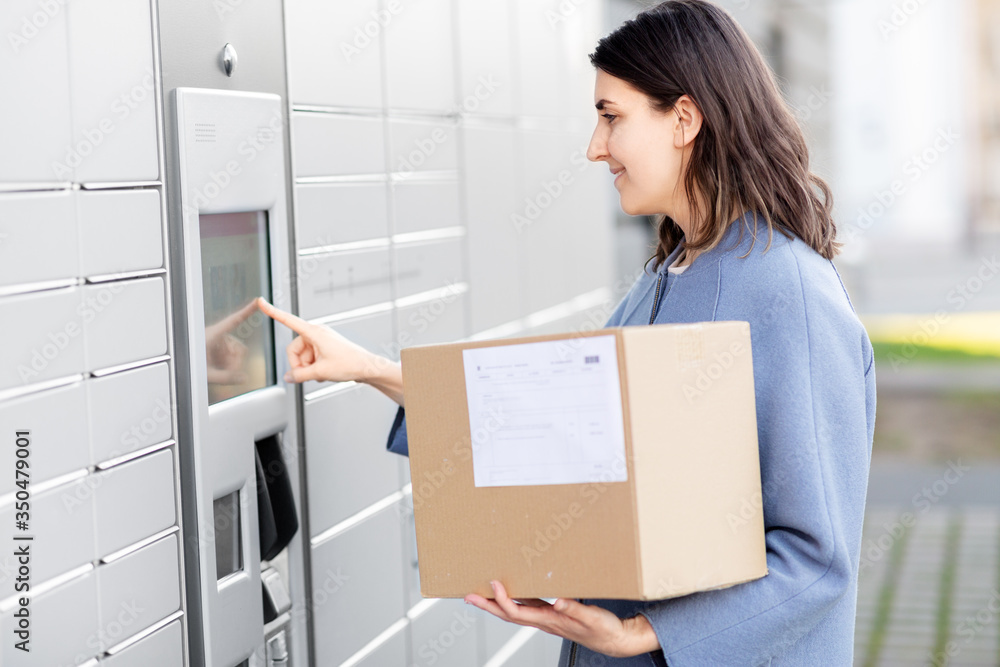 mail delivery and post service concept - happy smiling woman with box at outdoor automated parcel machine choosing operation on touch screen mail delivery and post service concept - happy smiling woman with box at outdoor automated parcel machine choosing operation on touch screen