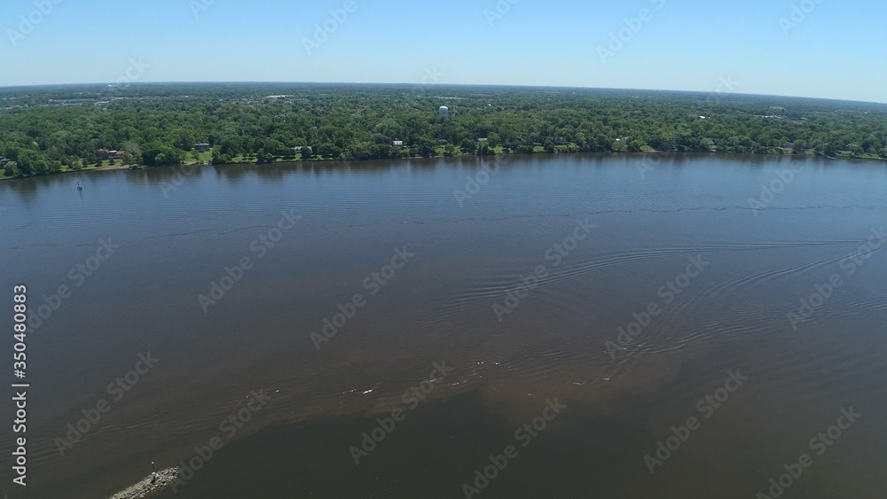 Bird's eye view of river and treeline, and churning waters.