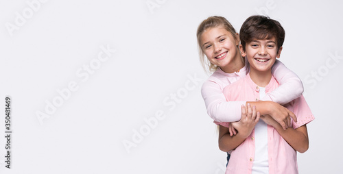 Copy-space sister hugging brother photo