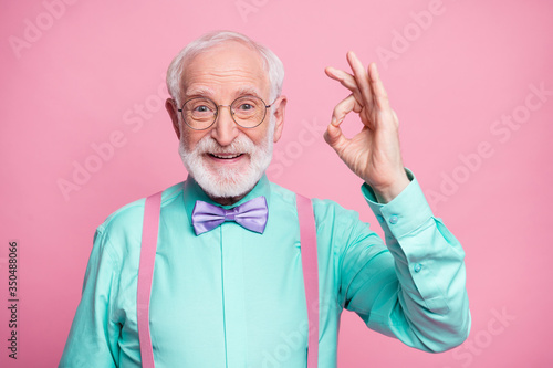 Portrait of positive cheerful old gentleman show okay sign decide choose perfect ads decisions choice wear good look outfit purple bow tie isolated over pastel color background photo