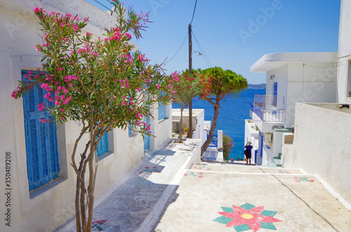 Fototapeta Naklejka Na Ścianę i Meble -  Picturesque scenic narrow streets with traditional whitewashed houses with blue doors windows of Milos town in famous tourist attraction Milos island, Greece in the Aegean during cruise