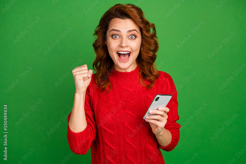 Portrait of delighted positive crazy woman use cellphone get social network lottery win notification impressed scream yeah wear jumper isolated over bright shine color background Portrait of delighted positive crazy woman use cellphone get social network lottery win notification impressed scream yeah wear jumper isolated over bright shine color background