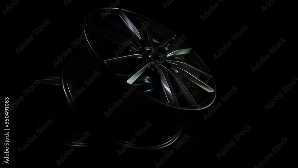 Modern automotive alloy wheel made of aluminum on a black background, industry. Designer fashion wheels for car, mechanic, copy space Modern automotive alloy wheel made of aluminum on a black background, industry. Designer fashion wheels for car, mechanic, copy space