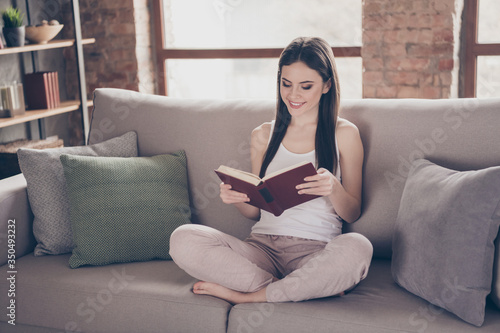 Free Download Full size photo of content pretty girl sit divan legs crossed read favorite story book enjoy wear white singlet pants in living room interior house indoors - GFXLoad