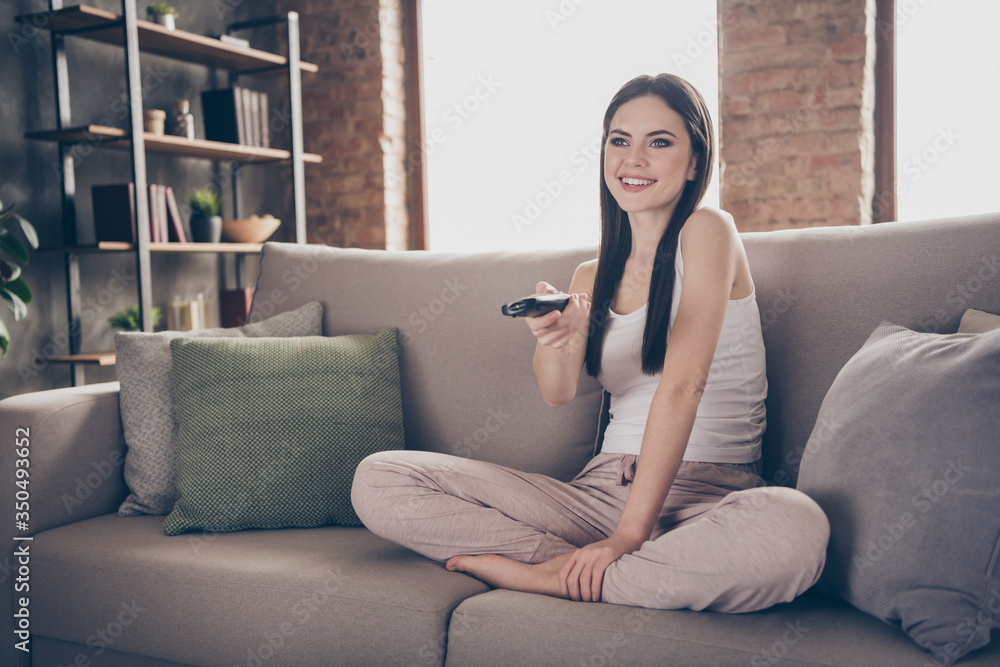 Full body photo of charming people dream dreamy sit divan remote control switch channel watch interesting film in living room apartment indoors Full body photo of charming people dream dreamy sit divan remote control switch channel watch interesting film in living room apartment indoors