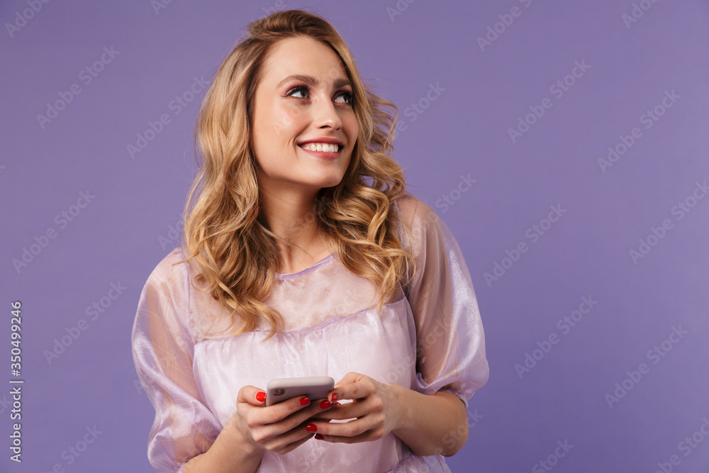 Image of happy young woman smiling and typing on smartphone Image of happy young woman smiling and typing on smartphone