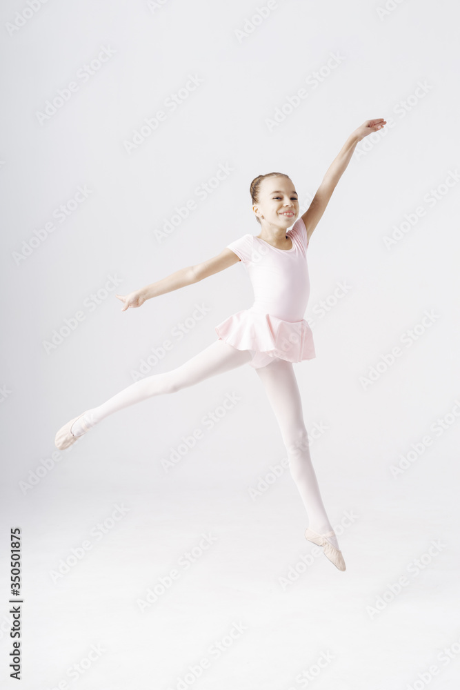 Delicate girl ballerina jumping on white background in studio. Kinds personality development concept.