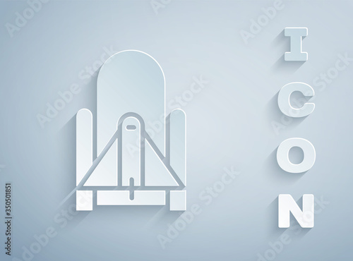 Paper cut Rocket launch from the spaceport icon isolated on grey background. Launch rocket in space. Paper art style. Vector