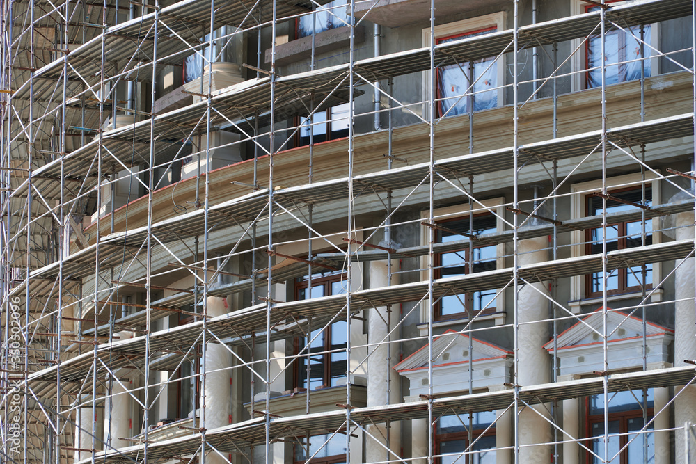 scaffolding at the facade of a building under construction, multi-storey building, without people