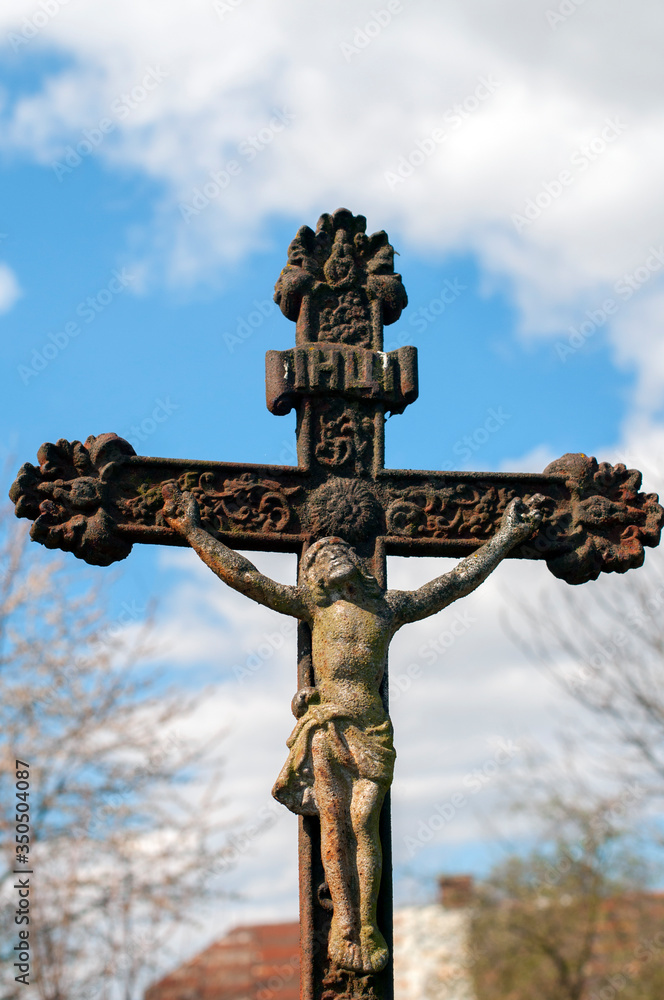 crucifix and the Virgin in the old cemetery. Crucifixion against the sky with clouds and old crosses.