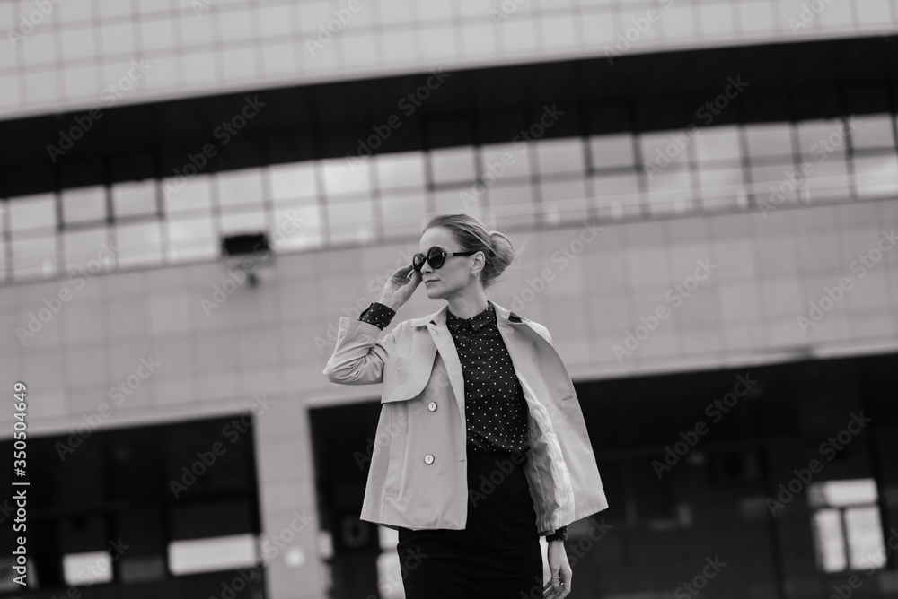 Fototapeta premium Young beautiful businesswoman with sunglasses, phone, laptop, cup of coffee in the city streets.