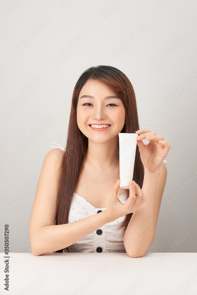 Asian woman model present showing cosmetic make up package products empty copy space on her hand palm Asian woman model present showing cosmetic make up package products empty copy space on her hand palm