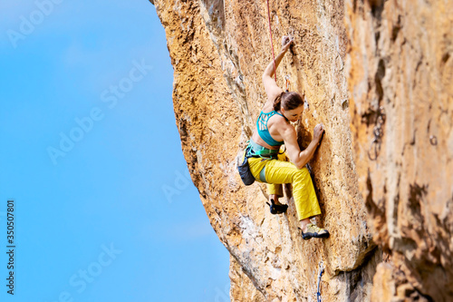 Woman climbs a rock.