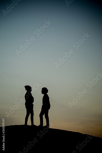 a silhouette couple standing facing each other