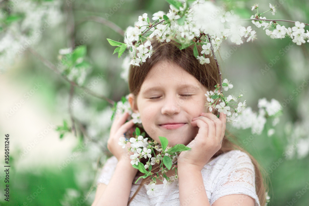 Cute tender Caucasian young girl with closed eyes near a flowering tree, a child with cherry blossoms. Concept of spring, freedom and tenderness. Cute tender Caucasian young girl with closed eyes near a flowering tree, a child with cherry blossoms. Concept of spring, freedom and tenderness.