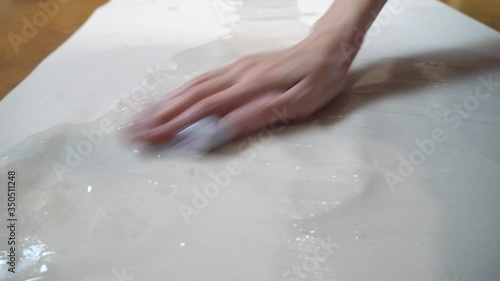 Wallpaper Mural A woman glues wallpaper in her apartment, applies glue to a paper wallpaper with a rag and spreads it around the edges. Torontodigital.ca