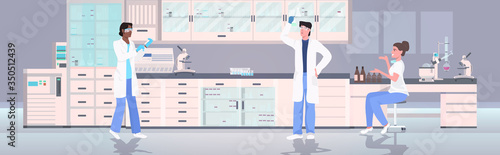 scientists holding test tubes working in medical lab mix race researchers in white coats making chemical experiments modern laboratory interior horizontal full length vector illustration
