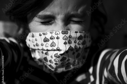 Ritratto bambina che piange con mascherina bianco e nero photo