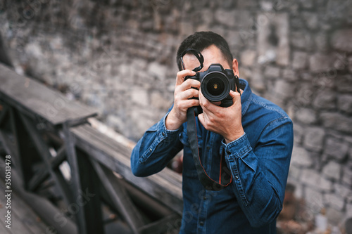 Travel, technology and life style concept: Portrait of a photographer covering her face with the camera.