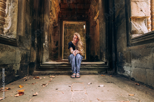 Cambodia. corridors of angkor wat. A girl with beautiful long blond hair is sitting on the floor. Ruins, Antiquity. Ancient architecture. Travels © Margarita Timofeeva