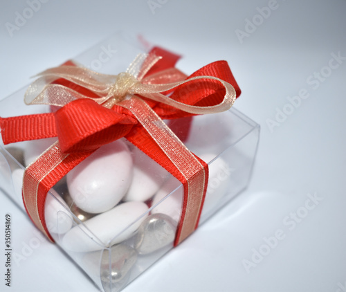 Small transparent package with red bow, gift for communions,
details for weddings, christmas and birthdays photo