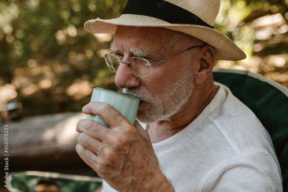 Senior man having refreshing coffee at campsite Senior man having refreshing coffee at campsite