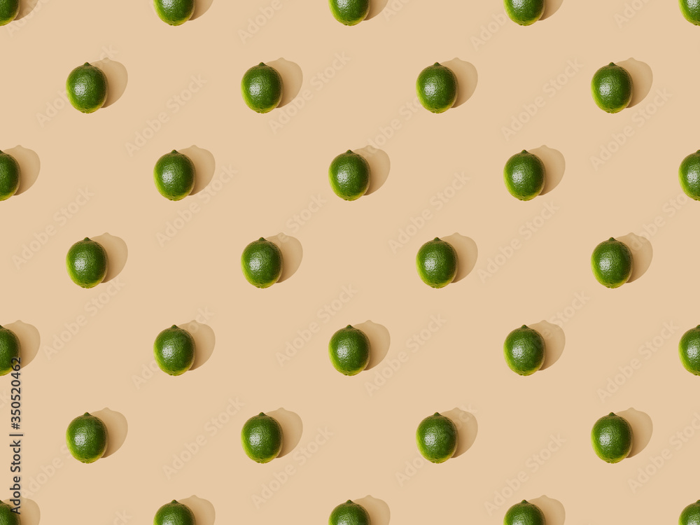 top view of fresh whole limes on beige background, seamless pattern top view of fresh whole limes on beige background, seamless pattern