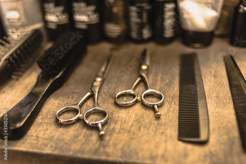 professional scissors and combs lie on a shelf in a hairdresser