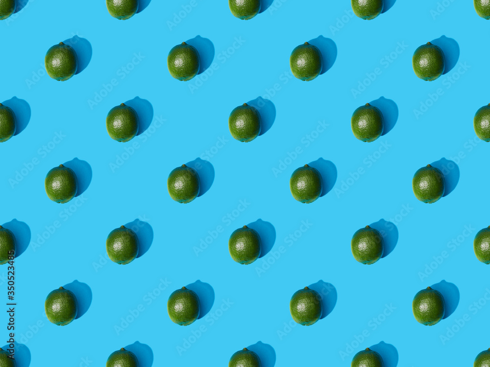top view of fresh whole limes on blue colorful background, seamless pattern top view of fresh whole limes on blue colorful background, seamless pattern