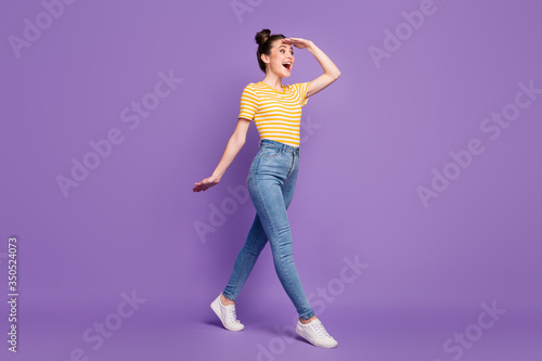 Full length body size view of nice attractive lovely pretty glad cheerful cheery girl strolling looking friend far away isolated on bright vivid shine vibrant lilac violet purple color background