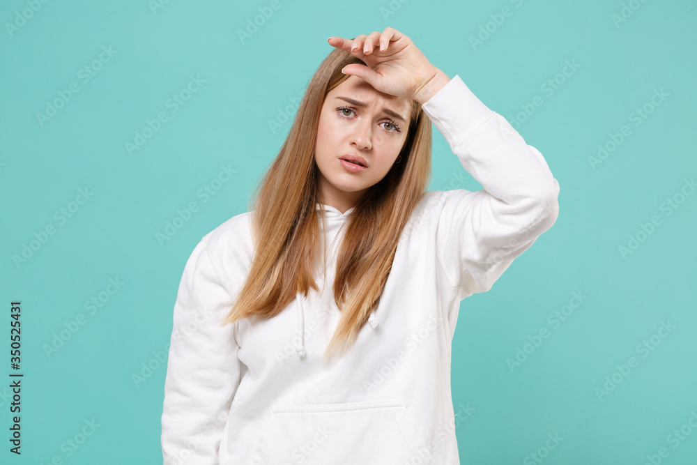Exhausted tired young woman girl in casual white hoodie posing isolated on blue turquoise background studio portrait. People sincere emotions lifestyle concept. Mock up copy space. Put hand on head. Exhausted tired young woman girl in casual white hoodie posing isolated on blue turquoise background studio portrait. People sincere emotions lifestyle concept. Mock up copy space. Put hand on head.