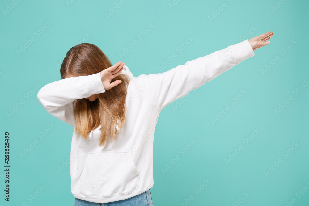 Young woman girl in casual white hoodie posing isolated on blue turquoise wall background studio portrait. People sincere emotions lifestyle concept. Mock up copy space. Showing DAB dance gesture. Young woman girl in casual white hoodie posing isolated on blue turquoise wall background studio portrait. People sincere emotions lifestyle concept. Mock up copy space. Showing DAB dance gesture.