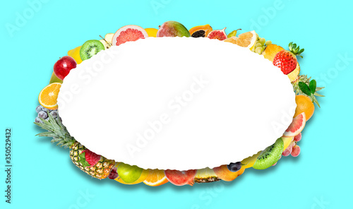 Creative photo of many different exotic tropical bright fruits with shadows on a blue background and an isolated white oval with beautiful jagged edges in the center for text. Bright summer pattern.