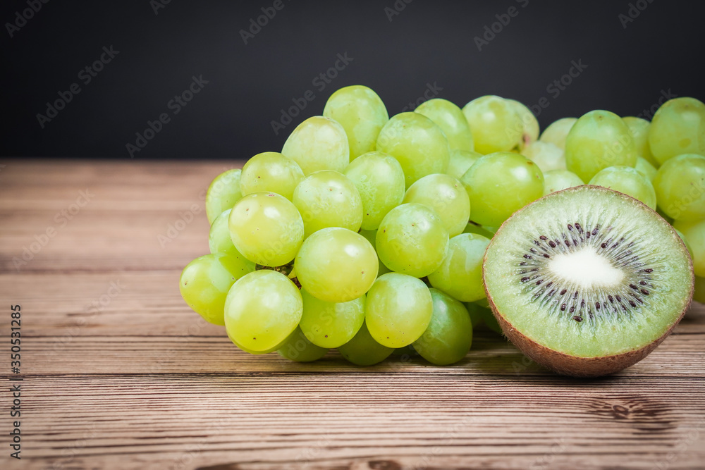 Vegetarian healthy food. Source of protein for vegetarians. Healthy eating: kiwi, grapes on dark background. Vegetarian healthy food. Source of protein for vegetarians. Healthy eating: kiwi, grapes on dark background.