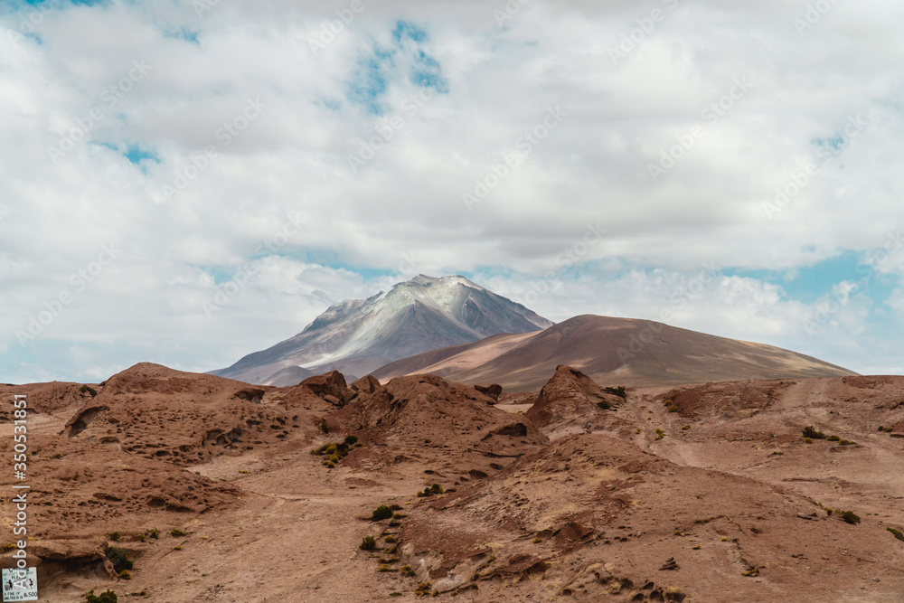 Rocky landscape mountain background. Dry, Barren desert, snowcapped mountains wilderness. Mountain range view. Salt Flats of Uyuni, Bolivia. Copy space, Rocks, blue sky, nature, hiking, sand dust