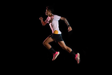 Asian man young sprinter runner running in studio on black background