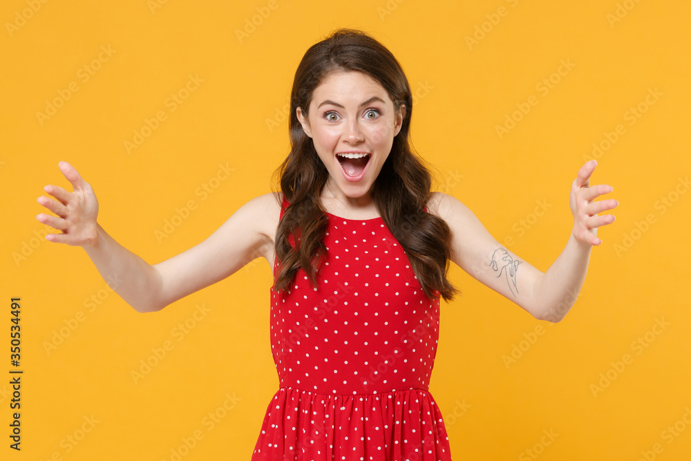 Excited young brunette woman girl in red summer dress posing isolated on yellow background studio. People lifestyle concept. Mock up copy space. Gesturing demonstrating size with horizontal workspace. Excited young brunette woman girl in red summer dress posing isolated on yellow background studio. People lifestyle concept. Mock up copy space. Gesturing demonstrating size with horizontal workspace.