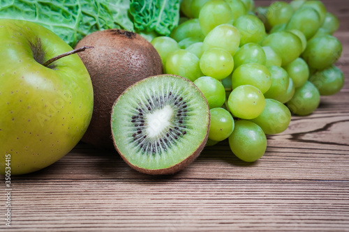 Vegetarian healthy food. Source of protein for vegetarians. Healthy eating  vegetable  kiwi  leaf vegetable  apple  grapes on wooden table.
