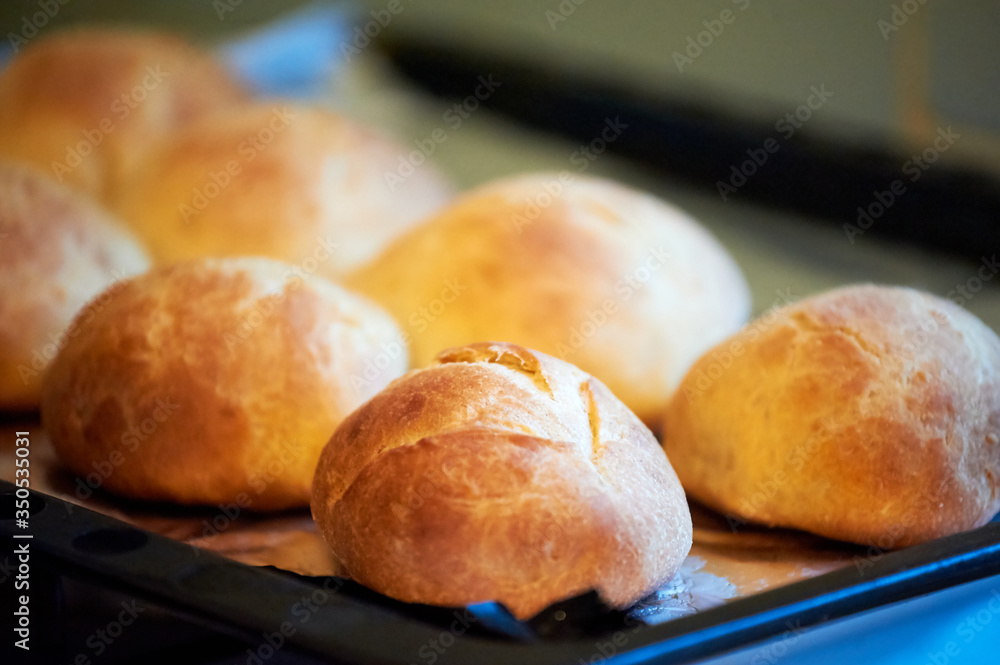 Freshly baked buns on a black tray. Selective focus