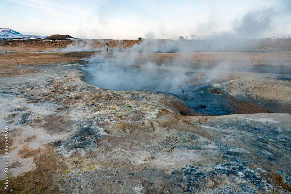 Hverarond geothermal area in Myvatn, Iceland. Steam vents and hot pools, muddy hot soil, sulfur smoke and colorful textures and patterns during blue hour.