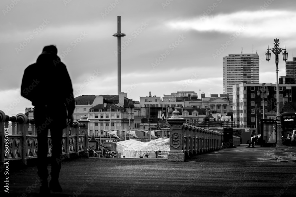 man walking along Brighton sea front