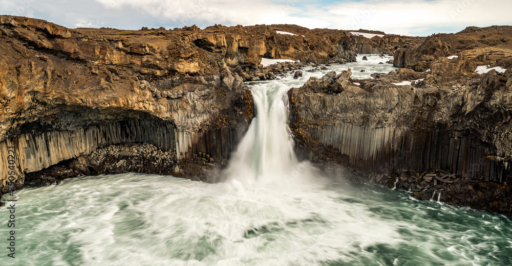 Aldeyjarfoss waterfall canyon in the highlands of Iceland. Basalt columns and powerful water flow on a sunny day.