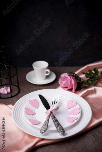 High angle of cutlery on plates with hearts and copy space