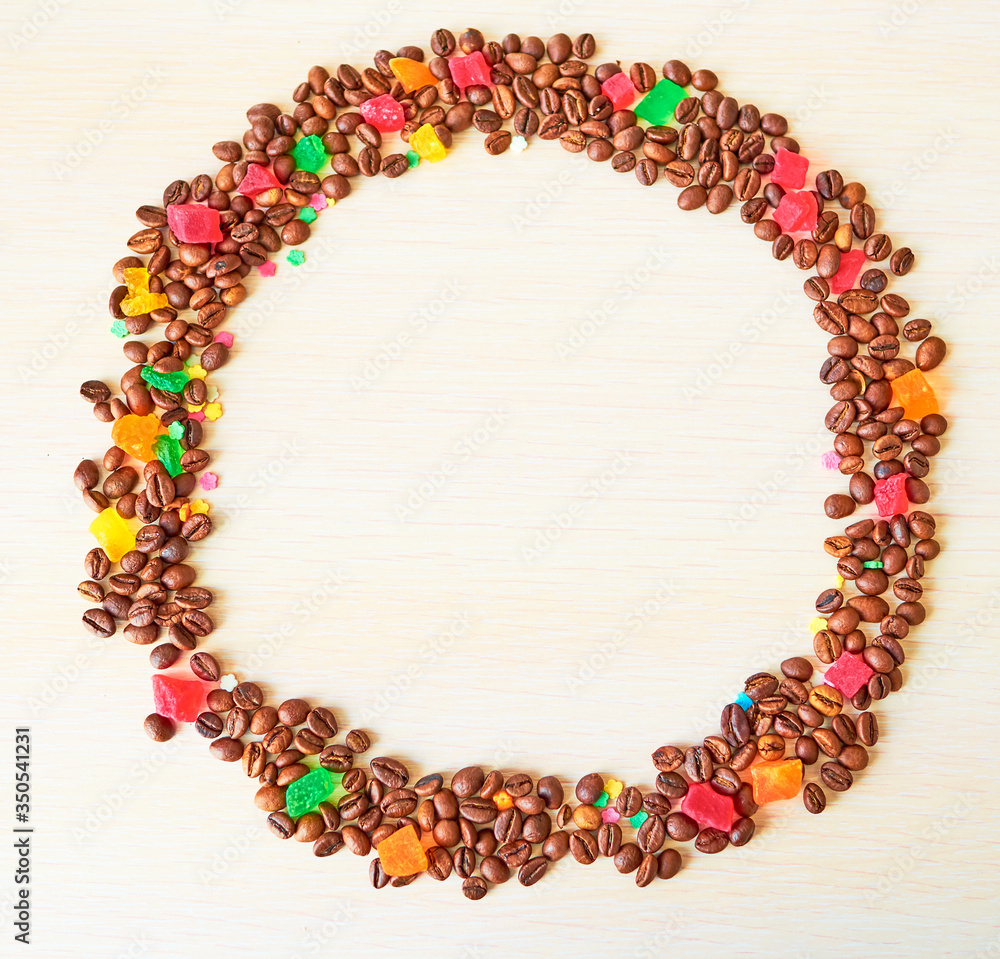 A circle of coffee beans and multi-colored candied fruits. Template. Background A circle of coffee beans and multi-colored candied fruits. Template. Background