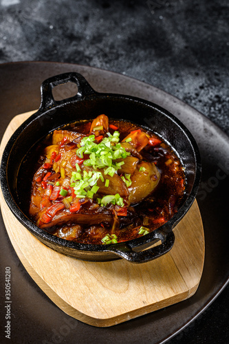 baked eggplant with spices and fresh green onions. Black background. Top view