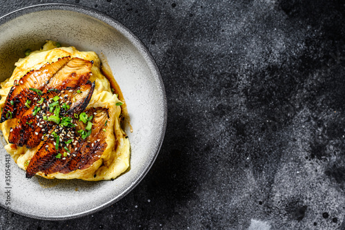 Baked eel with Japanese omelette and rice. Black background. Top view. Copy space