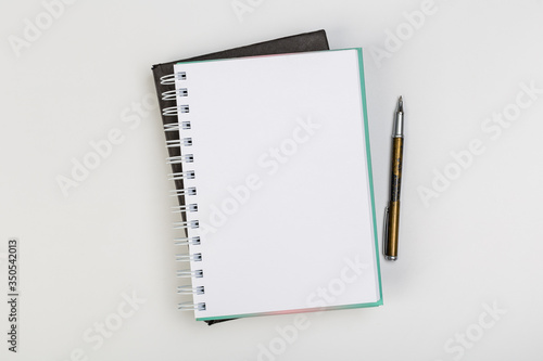 stack of colorful notebooks with pen isolated on white background