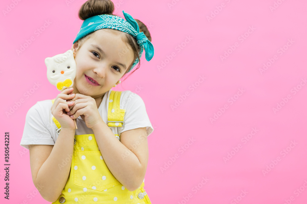 Little girl holding sweet lollipop candy. Pink background Little girl holding sweet lollipop candy. Pink background