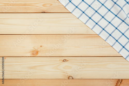 Top view on a wooden table with a linen kitchen towel or textile napkin.