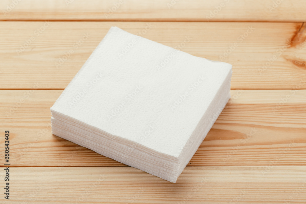 white paper napkin or tissue on the wooden table background.